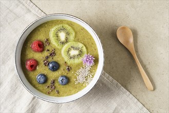 Kiwi smoothie bowl with blueberries, kiwi, white chia seeds and raspberries in a bowl