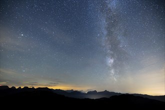 Clear starry sky with visible Milky Way and mountains in the background, Hochalp, Urnäsch,