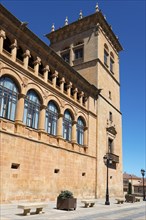 Historic tower with ornate arches and windows on a sunny day with a clear sky, Palacio de los