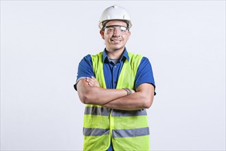 Portrait of smiling latin engineer with arms crossed isolated. Young latin engineer with helmet and