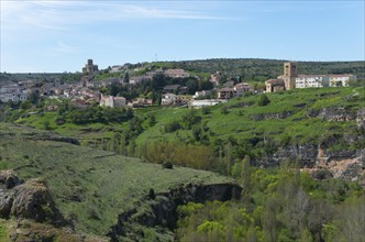 Landscape with hills, vegetation and a city view with historical buildings and a blue sky, City