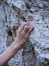 Close-up, hand of a climber grasping a small hold on the rock, Belove Stene climbing area, island