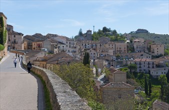 Quiet town with old houses on hills and people on the streets in sunny weather, city view,