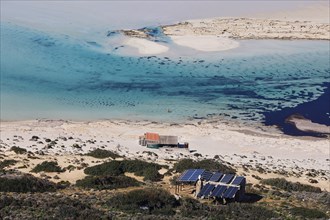 Caretaker building, Secluded beach with blue water and solar panels on the coast, Quiet and