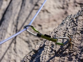 Climbing rope runs through a carabiner of an express sling, attached to a bolt, climbing area