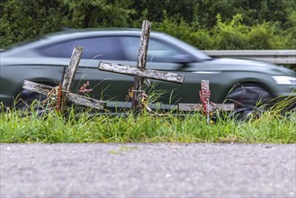 Cross on a country road, symbol of remembrance for three road accident victims. Laichigen,