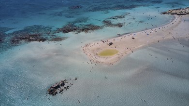 Overtourism, Aerial view of a sandbank in the sea with people swimming and relaxing in the clear