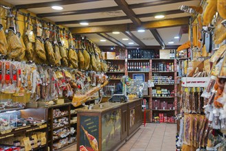 A rustic shop filled with hanging hams and other foods on the shelves, Plasencia, Cáceres, Caceres,