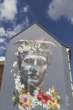 Portrait of a bigender person, bisexuality symbolised by horns and flower arrangement, mural by