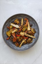 Overhead view of stir fried pork meat with mushrooms and black rice noodles