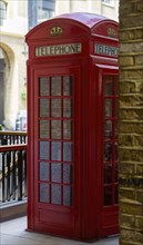 Historic red telephone box in a canopied street scene, stylised and classically British, London,