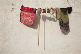 Clothes, shoes and a mop hanging to dry on a washing lineSilves, Algarve, Portugal, Washing line