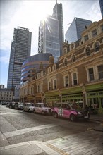 City scene with historic buildings and modern skyscrapers in the sunlight in the foreground are