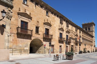 Historic building with ornate stone walls and arches on a sunny day under a clear sky, Palacio de