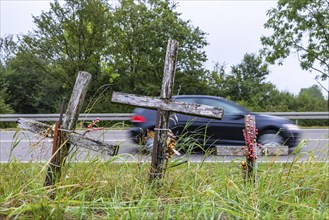 Cross on a country road, symbol of remembrance for three road accident victims. Laichigen,