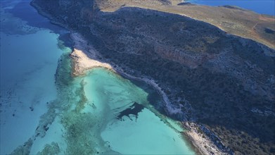 Drone shot, aerial view of a coastline with blue water and rocky shore, natural and idyllic view,