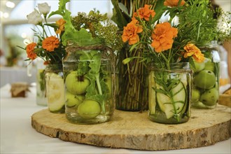 Concept of festive decoration of table, fruits and plants in jar with water