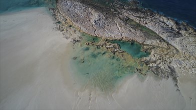 Drone shot, coastline with light-coloured sand and crystal clear turquoise water, interspersed with