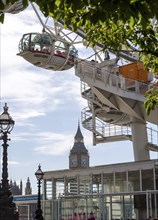 Capsules of the London Eye Ferris wheel with a view of the famous clock tower Big Ben, London,