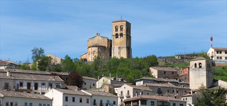 View of a city with a dominant church tower and various historical buildings under a blue sky, city