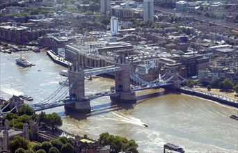 Aerial view of Tower Bridge over the river, surrounded by city buildings and boats, London, United