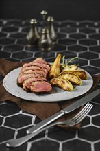 A succulent duck breast is perfectly seared and surrounded by tender, caramelized apple and pear