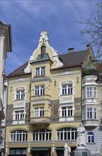 Historic building in the city centre with yellow façade and ornate cornices, Leonhaus,