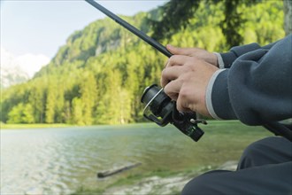 Fisherman s hand with spinning, autumn fishing season