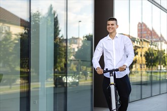 Young and casual business man riding electric scooter in the city