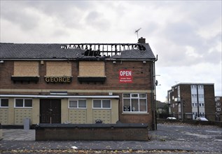 Leeds, England, September 24, 2017: A closed public house stands derelict and boarded on a housing