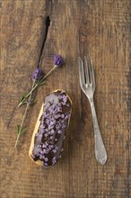 Eclair with chocolate ganache with candied lavender topping