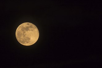 Blue Moon rising on 31 March 2018, landscape orientated image with Moon isolated on black