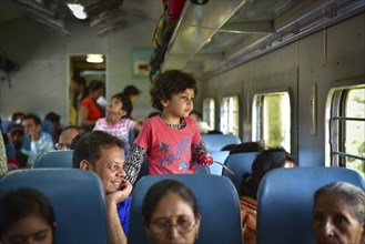 A girl and her father on the train looking outside the window in India