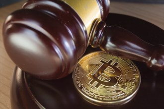 Bitcoin regulation. BTC cryptocurrency coin and judge gavel on a desk. Banned currency or law