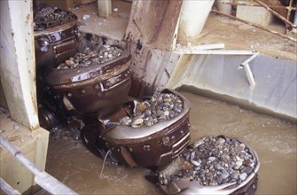 Bucket chain carries river bed gravel into the Ngahere Gold Dredge, West Coast, South Island, New