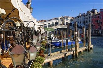 View of the Grand Canal, Rialto Bridge, and gondolas from outdoor restaurant seats, Venice, Italy,