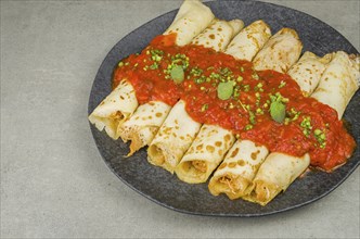 Brazilian pancakes with chicken, tomato bolognese sauce, rolled pancakes