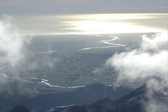 Cloud-covered snowy peaks in the Southern Alps, with the Pacific Ocean in the background, Westland,