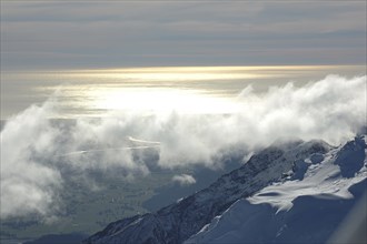 Cloud-covered snowy peaks in the Southern Alps, with the Pacific Ocean in the background, Westland,