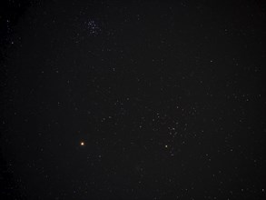 The planet Mars, with The Pleiades and part of the constellation of Taurus, with the red giant star