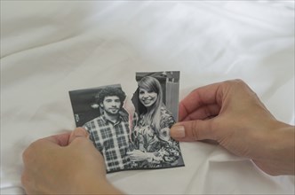 Great concept of divorce, betrayal, separation, woman hand ripping photo of the couple