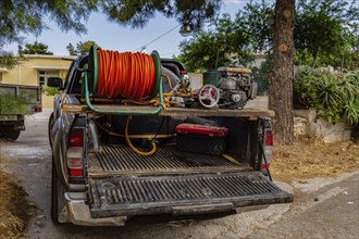 Pickup arranged in an irrigation truck with a tank and a water pump on the island of Crete in