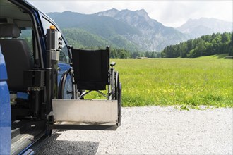 Photo of black electric lift specialized vehicle for people with disabilities. Empty wheelchair on