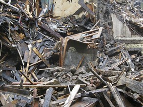 Black burned timbers and walls in a collapsed house destroyed by fire