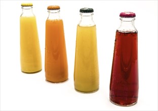 Four bottles of fruit juice, cherry, orange, pineapple, multifruit on a white background