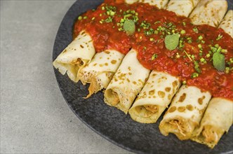 Brazilian pancakes with chicken, tomato bolognese sauce, rolled pancakes