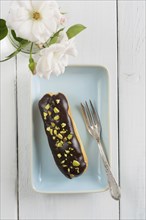 Eclair with chocolate ganache with pistachio topping