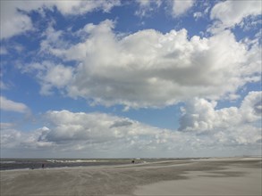 Extensive beach and sea under a sky with massive clouds, spiekeroog, east frisia, north sea,