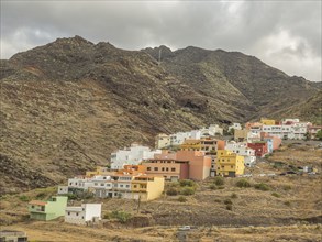 Small colourful houses scattered on the slope of a mountain, surrounded by nature, tenerife, canary