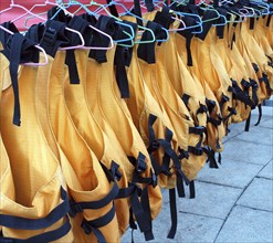 Orange life vests are drying on clothes hangers